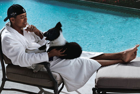 Tiger Woods sitting on the chair by the pool with his  Border Collie  dog on his lap
