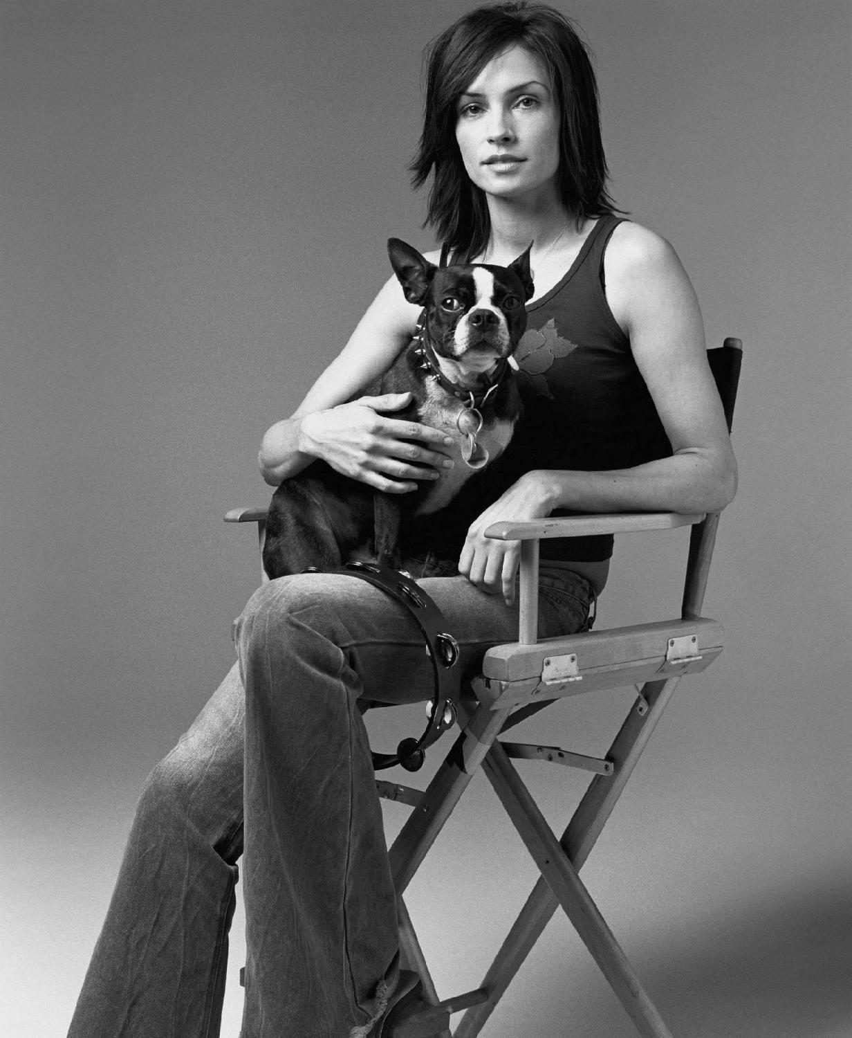 Famke Janssen sitting on the chair with herBoston Terrier dog