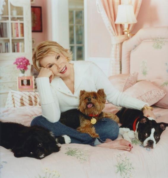 Joan Rivers sitting on the bed with her Boston Terrier