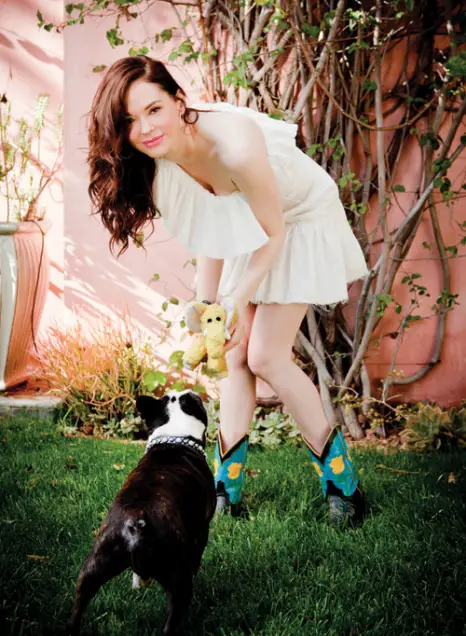 Rose Mcgowan in the garden playing with her Boston Terrier dog using a toy in her hand