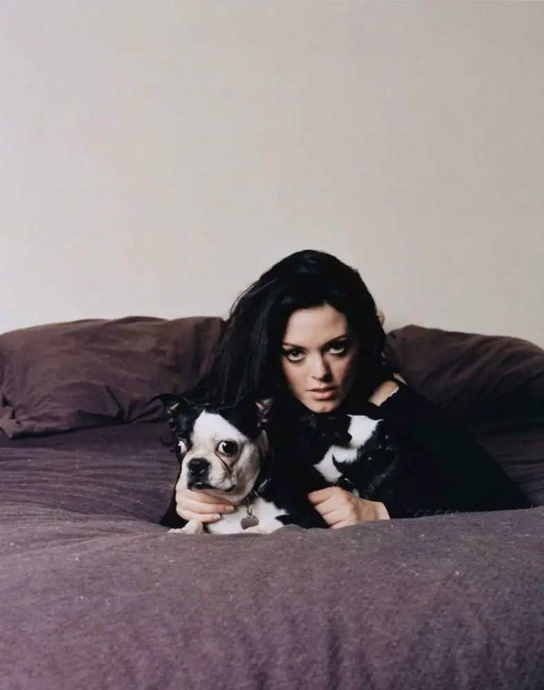 Rose Mcgowan on the bed with her Boston Terrier
