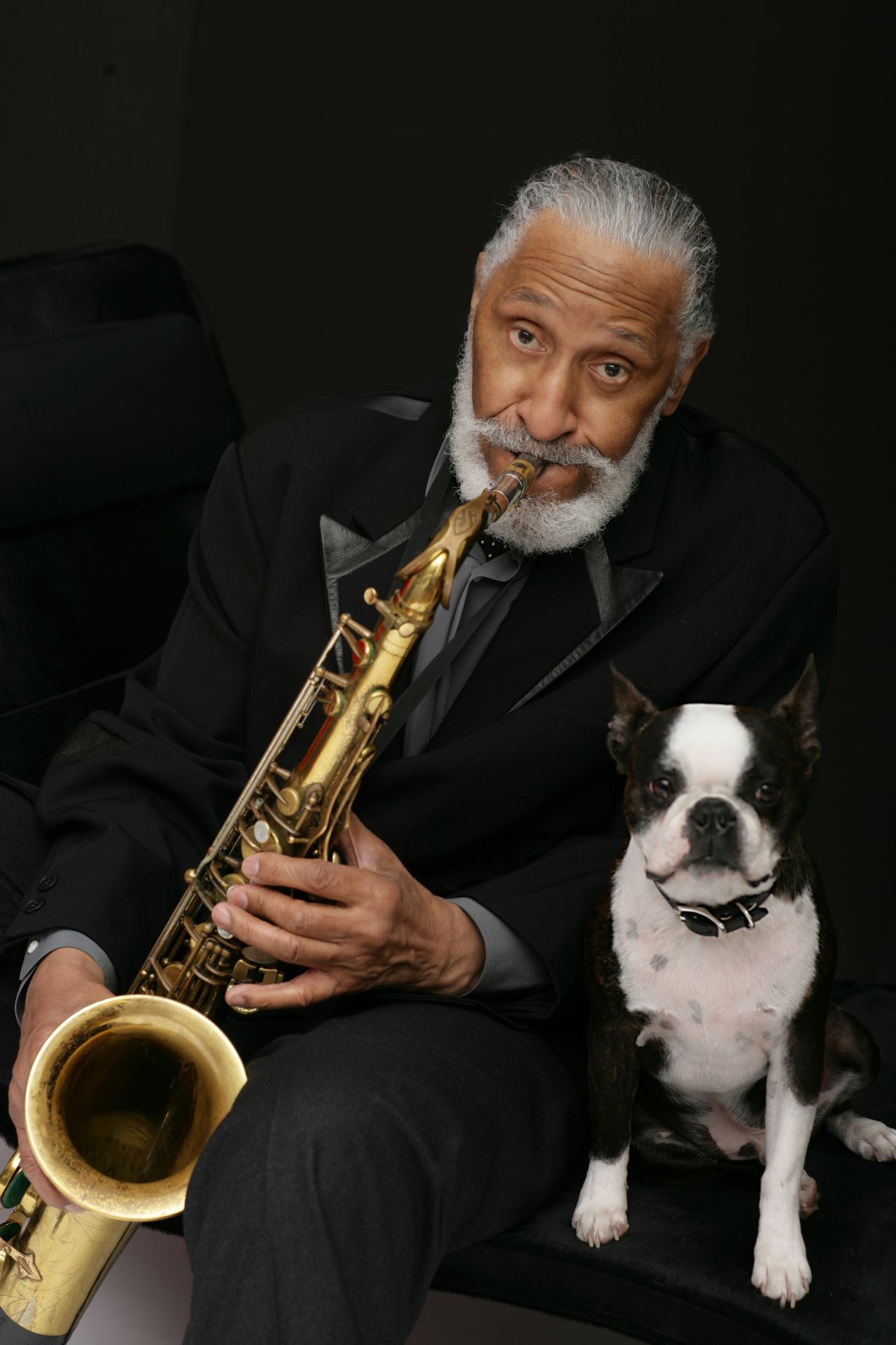 Sonny Rollins playing saxophone beside his Boston Terrier