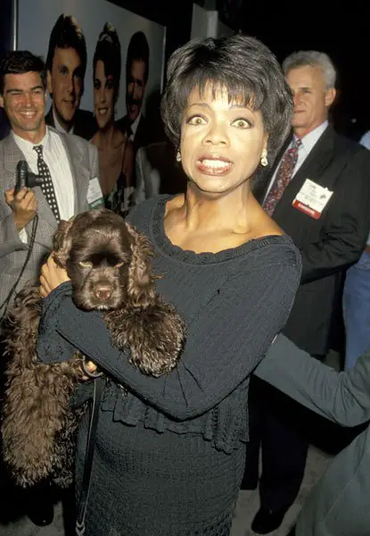 Oprah Winfrey in a crowd carrying her Cocker Spaniel