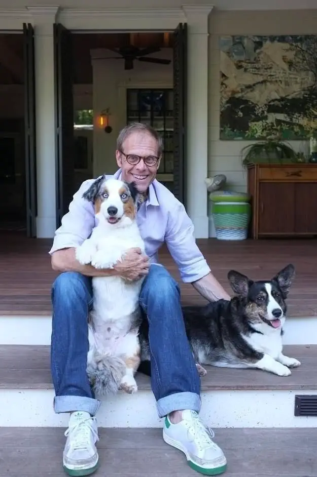 Alton Brown sitting in the front porch with his two Corgis