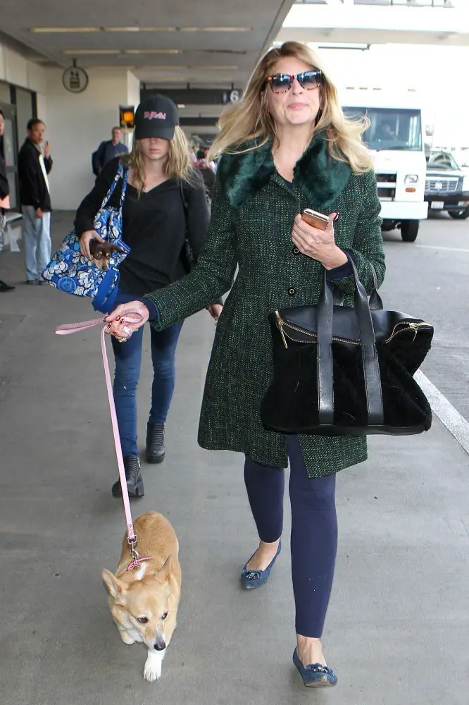 Kirstie Alley walking at the airport with her Corgi