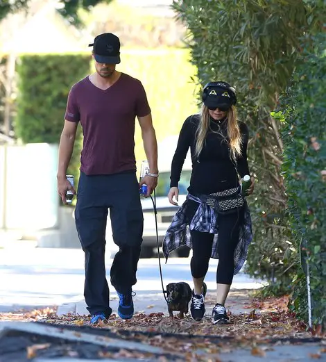 Fergie and Josh walking outside in the morning with their Dachshund 