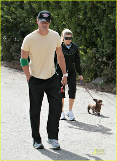 Josh and Fergie walking their Dachshund in the street