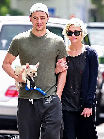 Ashlee Simpson walking in the street with a man carrying a French Bulldog puppy