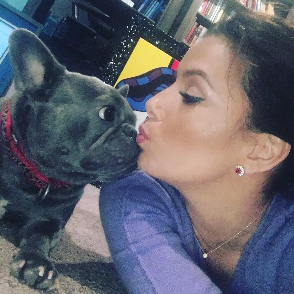Eva Longoria lying on the floor and kissing her French Bulldog next to her