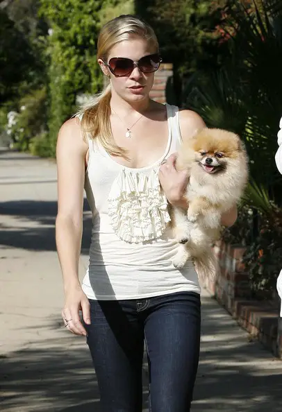 LeAnn Rimes walking in their village while carrying her Pomeranian