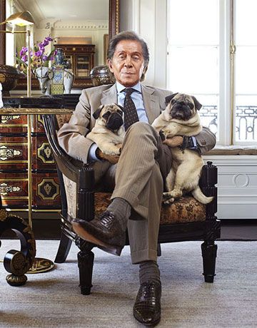 Valentino sitting on the chair with his two pugs on his side