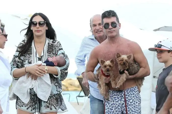 Simon Cowell carrying its two Yorkies
