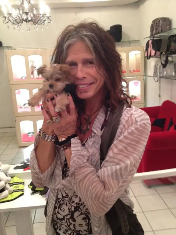 Steven Tyler holding her Yorkie puppy close to her face