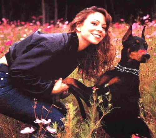 Mariah Carey in the filed of flowers with her Doberman puppy