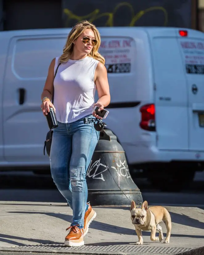 Hilary Duff walking in the parking lot with a French Bulldog on a leash
