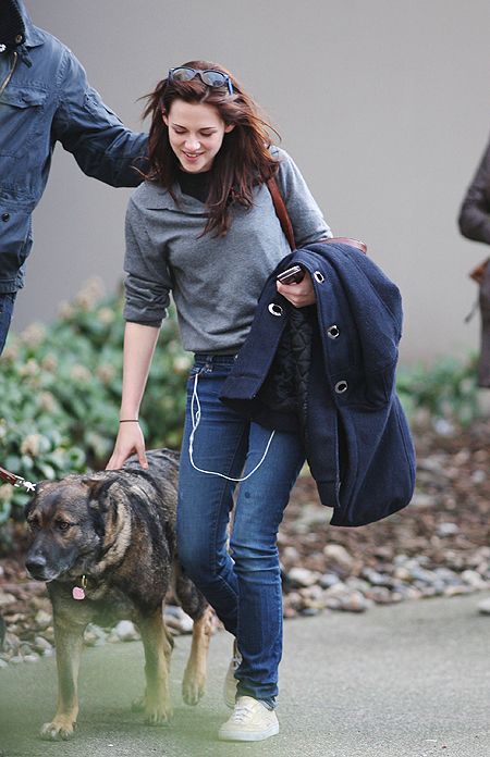 Kristen Stewart walking in the street next to her German Shepherd