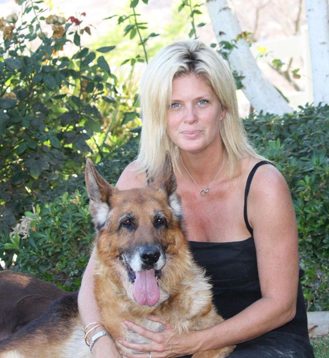 Rachel Hunter in the garden while embracing her German Shepherd dog