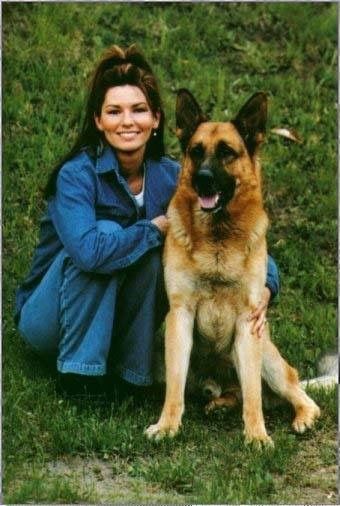 Shania Twain sitting on the grass with her German Shepherd next to her