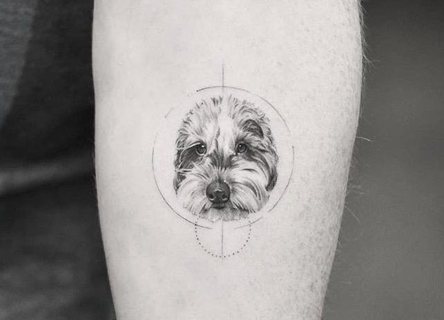 A minimalist black and gray Goldendoodle tattoo on the forearm