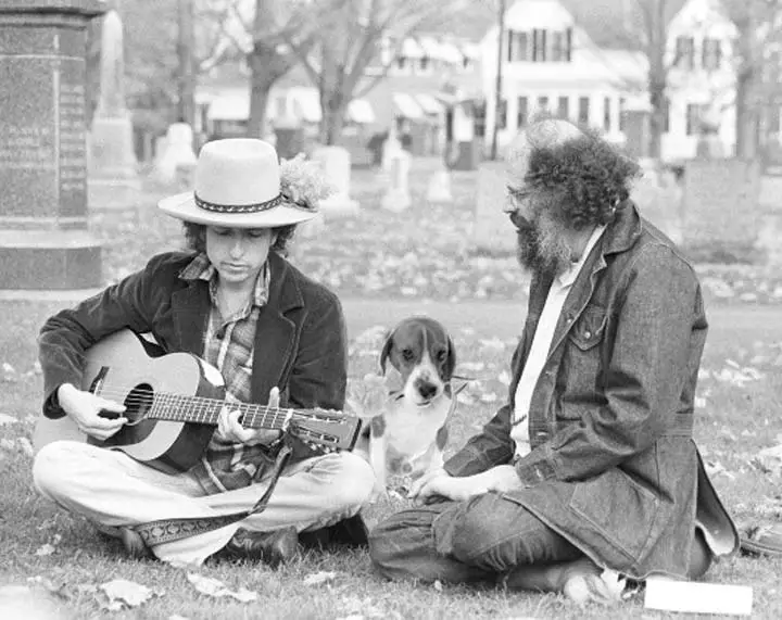 black and white photo of Bob Dylan sitting on the grass with his Beagle