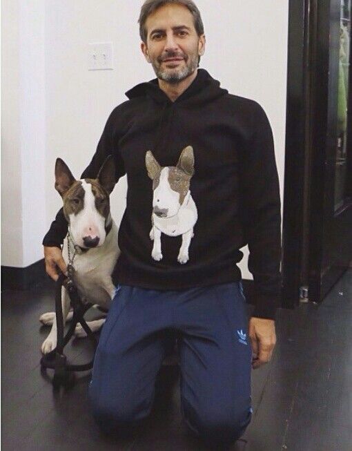 Marc Jacobs wearing a sweater with Bull Terrier print kneeling on the floor beside his Bull Terrier