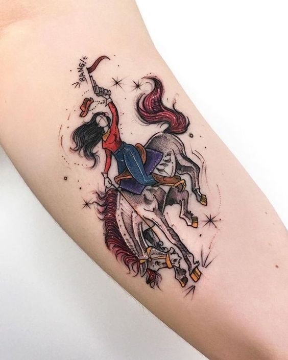 a girl riding a horse firing a gun while riding a horse artistic tattoo on the biceps of a woman