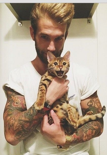a man holding a Bengal Cat
