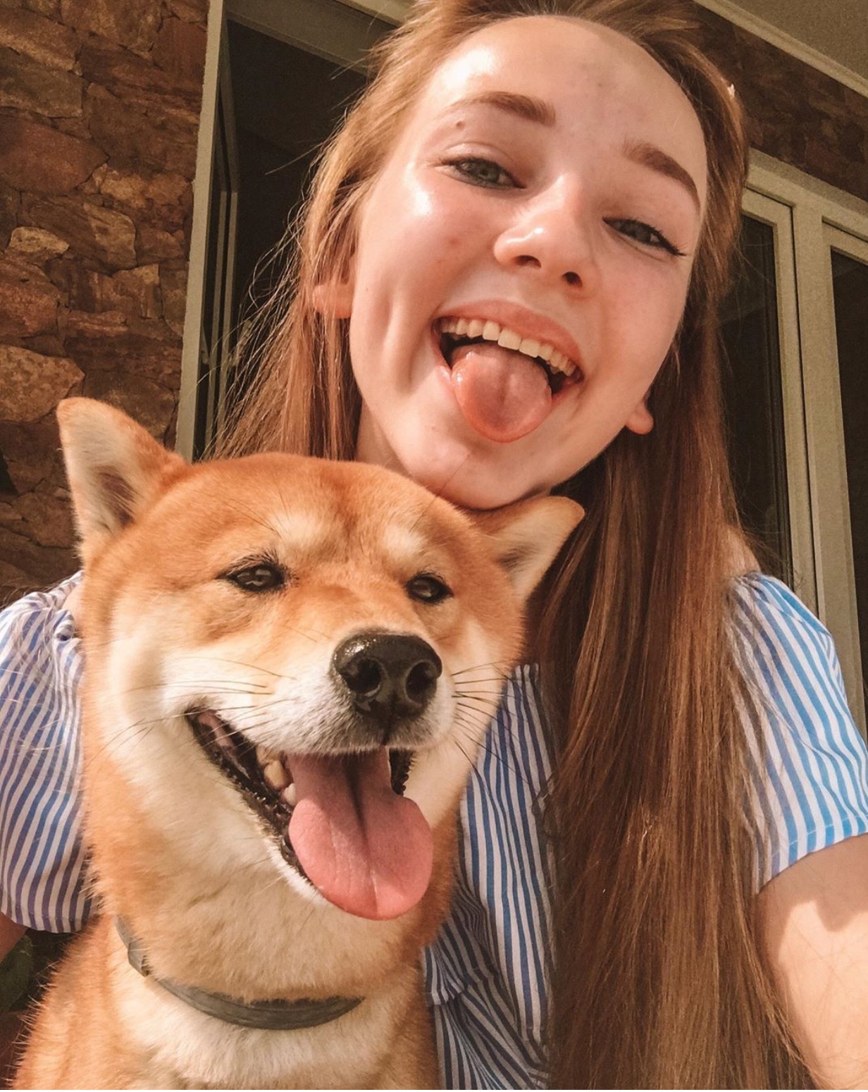 a woman taking a selfie with her Shiba Inu
