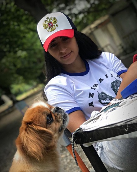 A Pekingese sitting on the chair with a Pekingese beside her