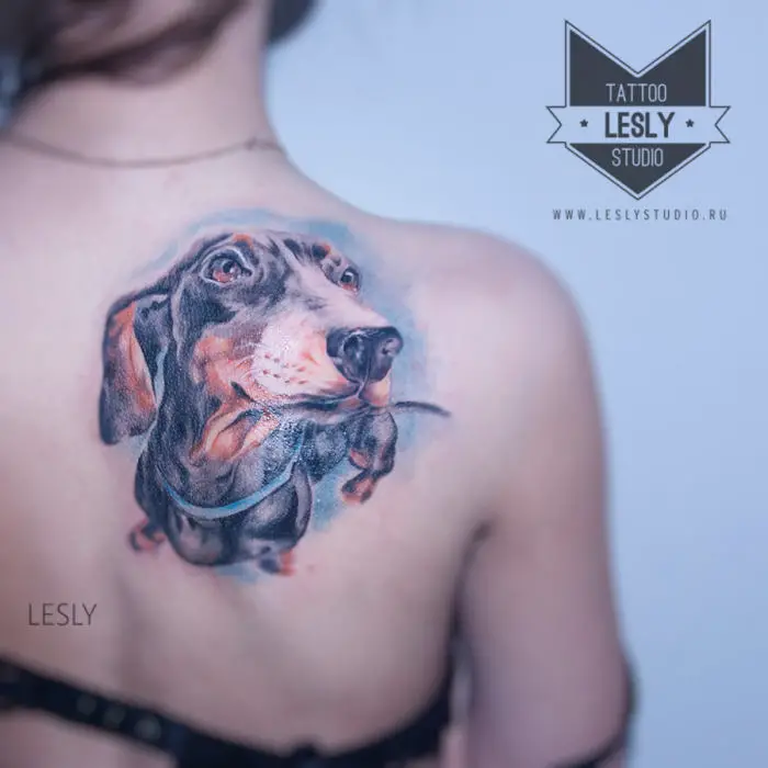 a realistic Dachshund tattoo on the back of a woman