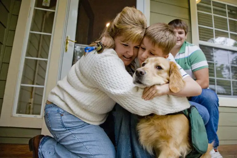 mother and son hugging a Golden Retriever