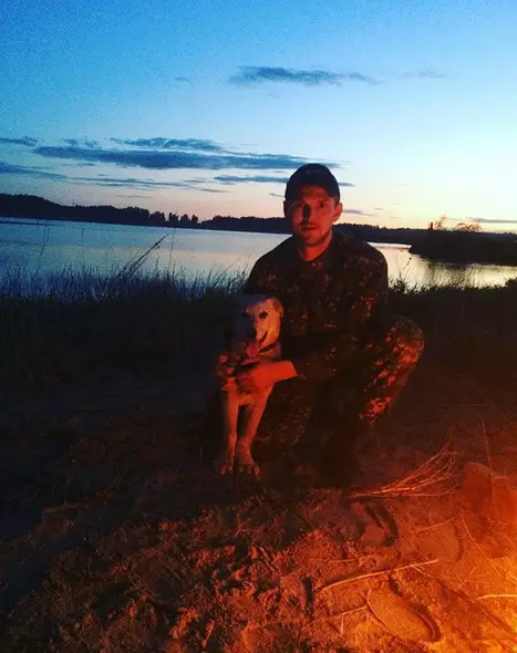 Golden Retriever with a man by the lake on a sunset