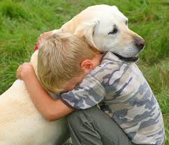 a kid hugging a Labrador