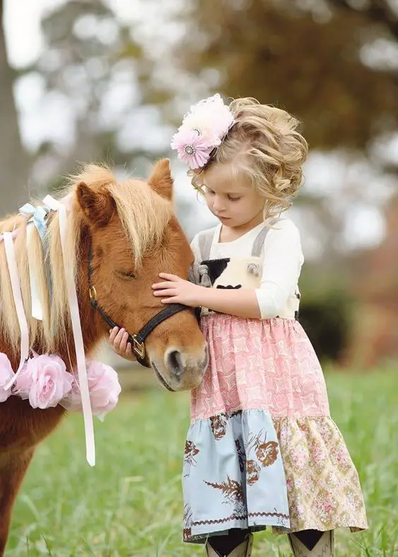 A little girl petting her horse