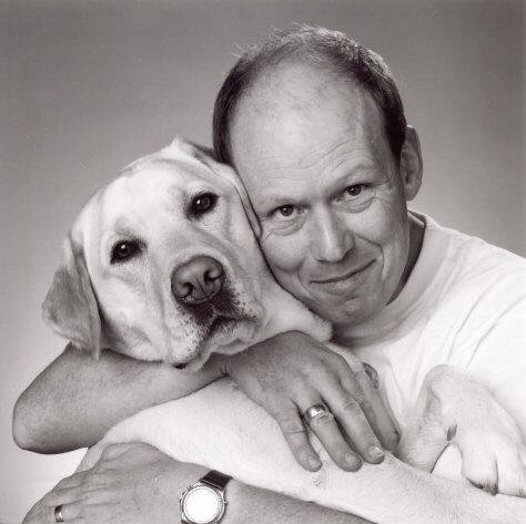 A man hugging his Labrador Retriever