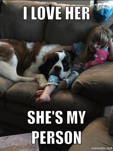 photo of a young girl sitting on the couch while embracing her Saint Bernard lying beside her and with text - I love her, she's my person