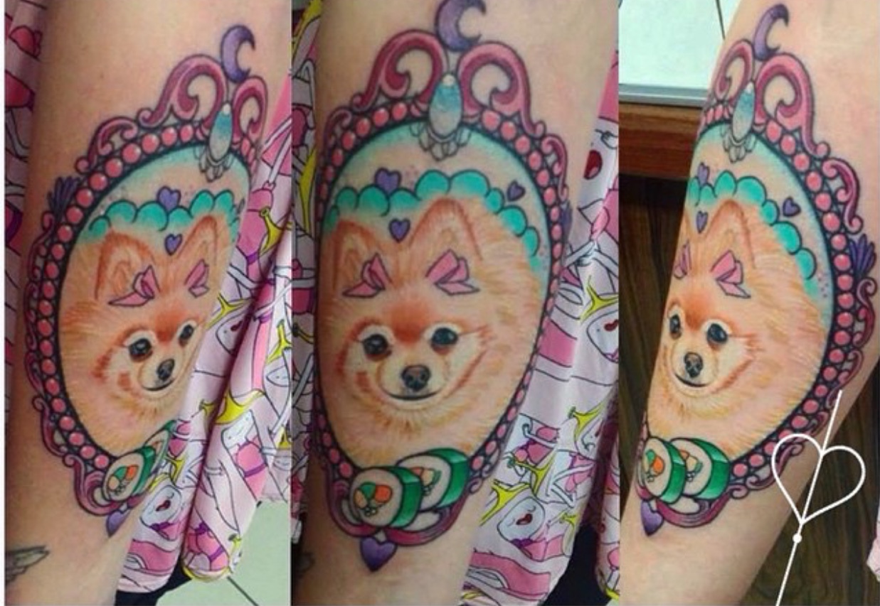 face of Pomeranian inside a pink vintage frame tattoo