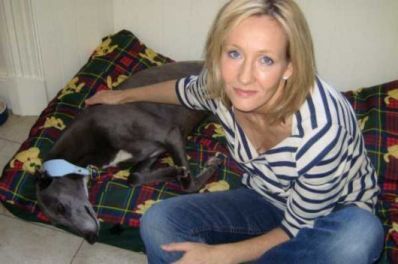 JK Rowling sitting next to her Greyhound sleeping on its bed