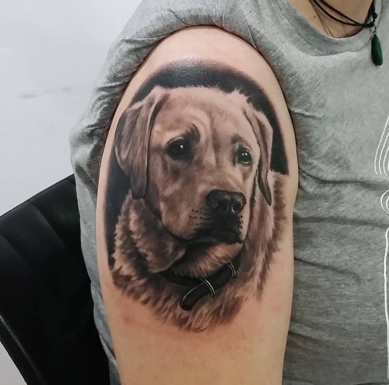 black and gray tattoo of a Labrador Retriever in a black shadow on the shoulder