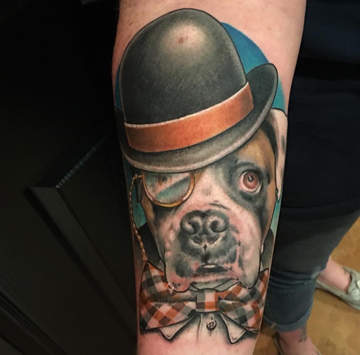 A Boxer wearing a hat realistic tattoo on the forearm