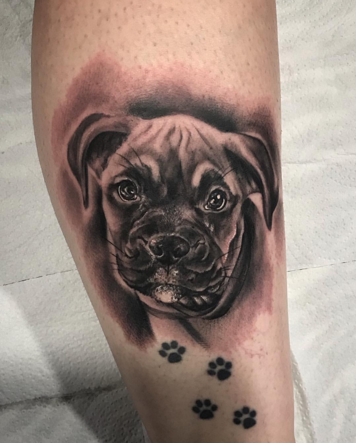 3D black and gray face of a Boxer tattoo on the leg