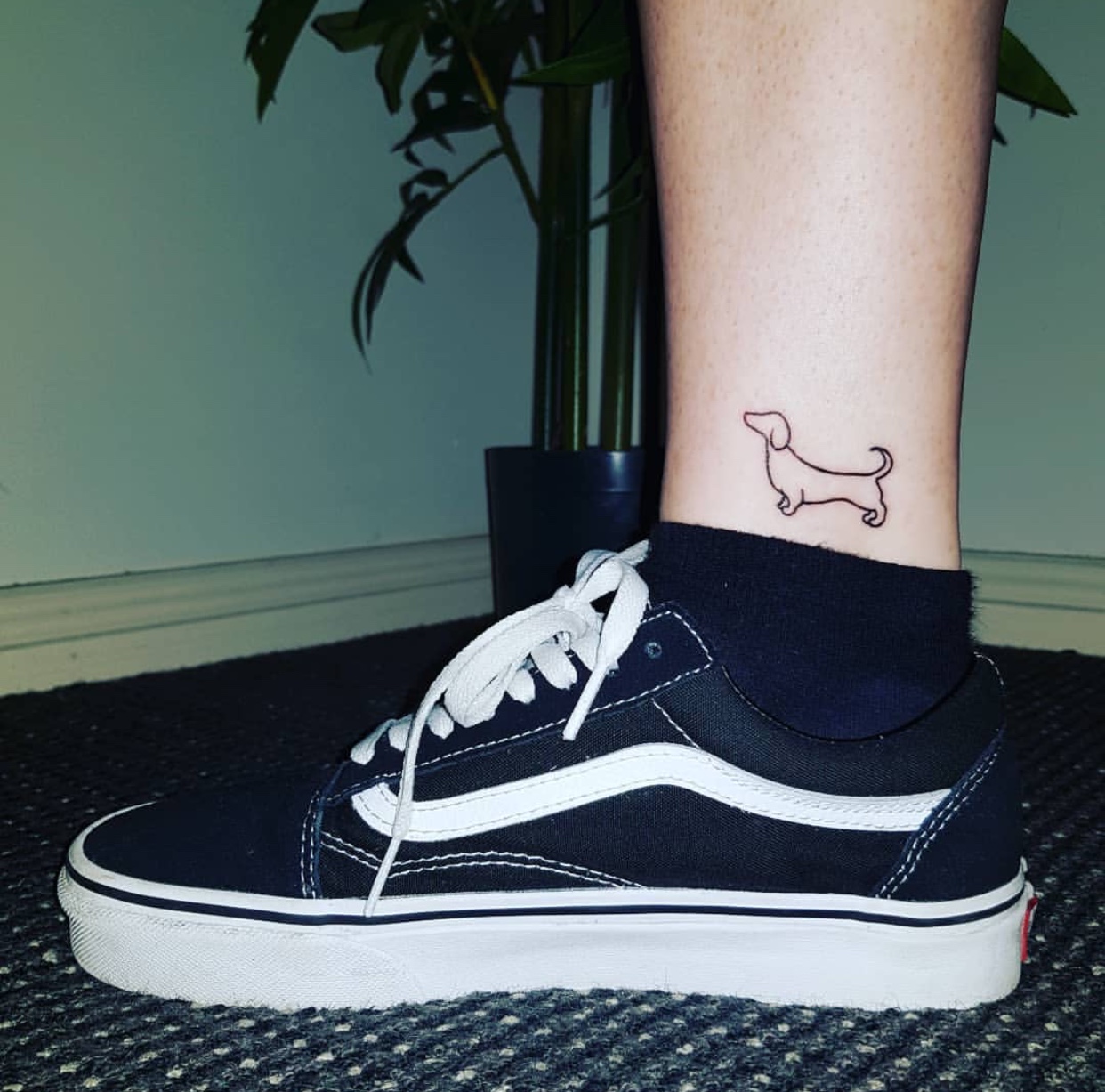 minimalist outline of Dachshund tattoo on the side of lower leg