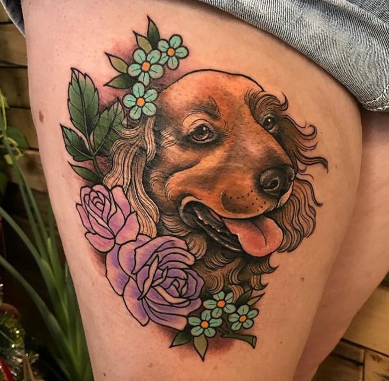 smiling Cocker Spaniel with flower and leaves tattoo on the thighs