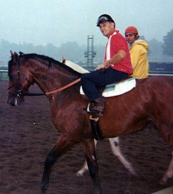 man riding a brown horse named Dr. Fager