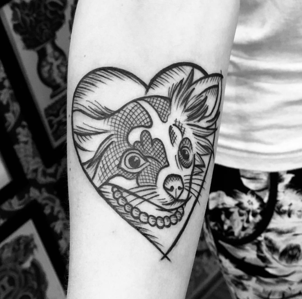 animated face of Chihuahua inside a hear tattoo on the forearm