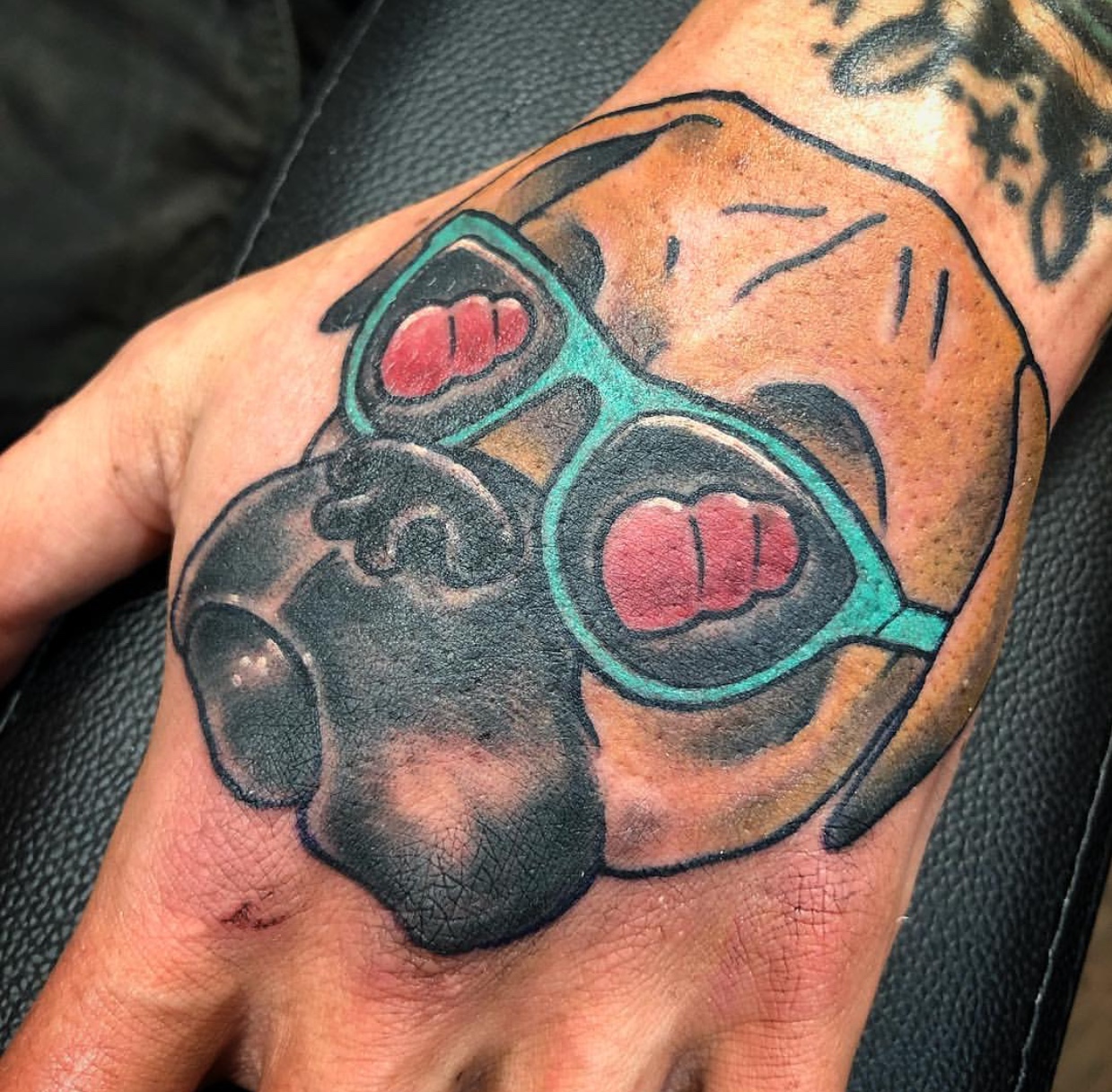 artistic face of a Boxer wearing sunglasses tattoo on the hand