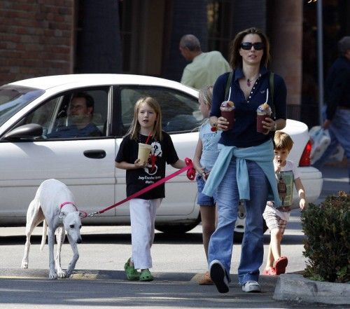 Tea Leoni walking in the street with her kids and their Greyhound