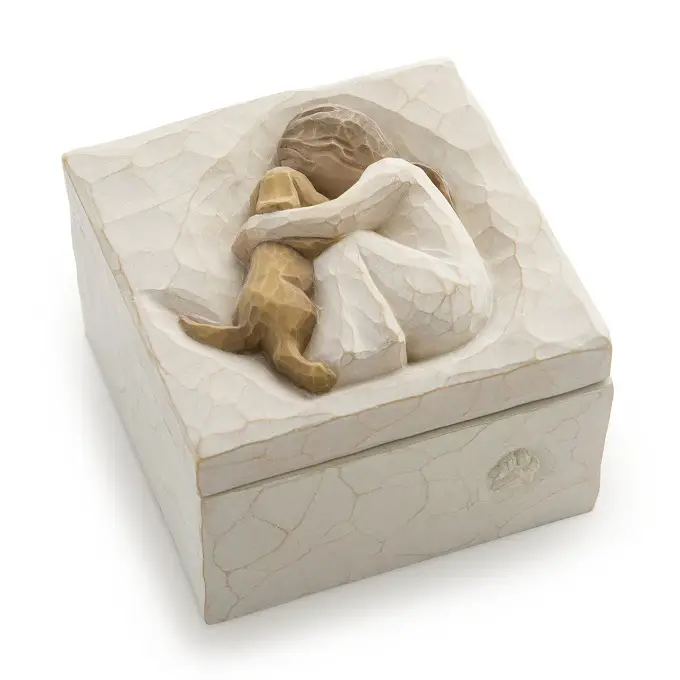 A sculpted hand-painted keepsake box of a girl hugging a Golden Retriever puppy