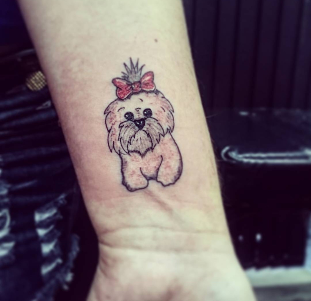 mustached Shih Tzu wearing a ribbon tie on top of its head tattoo on the wrist