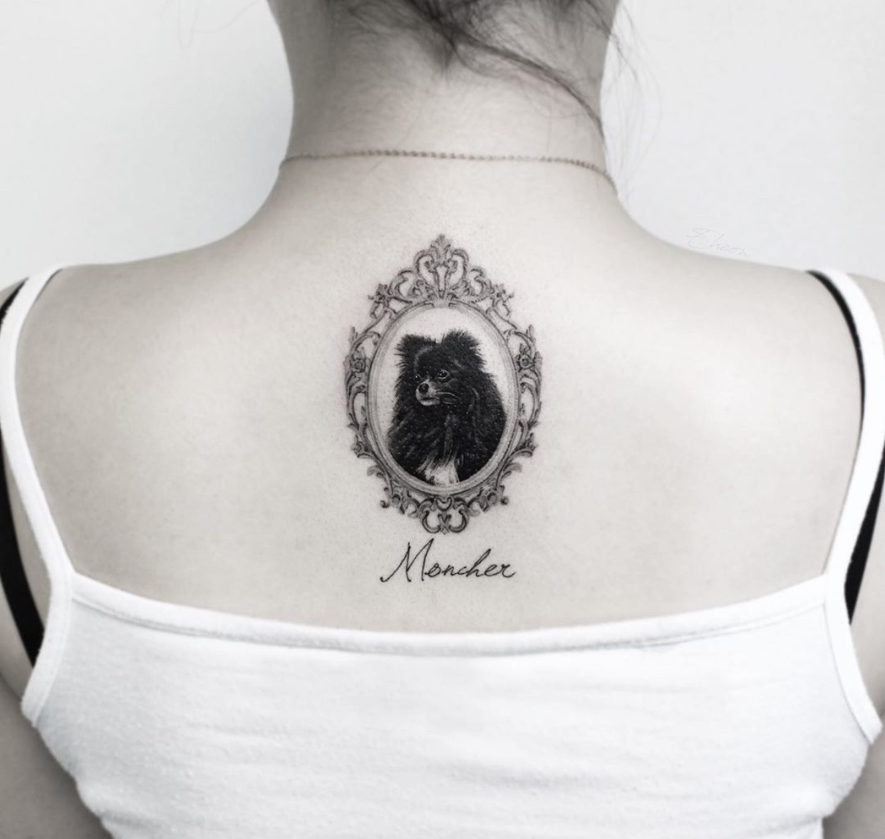 black and white photo of Pomeranian in a vintage frame tattoo on the back